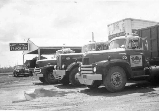 A black and white photo of two trucks parked in the parking lot.